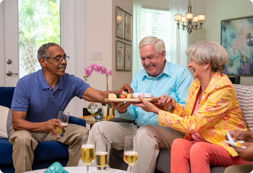 three senior residents enjoying a charcuterie board