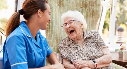 a senior lady laughing with a staff member
