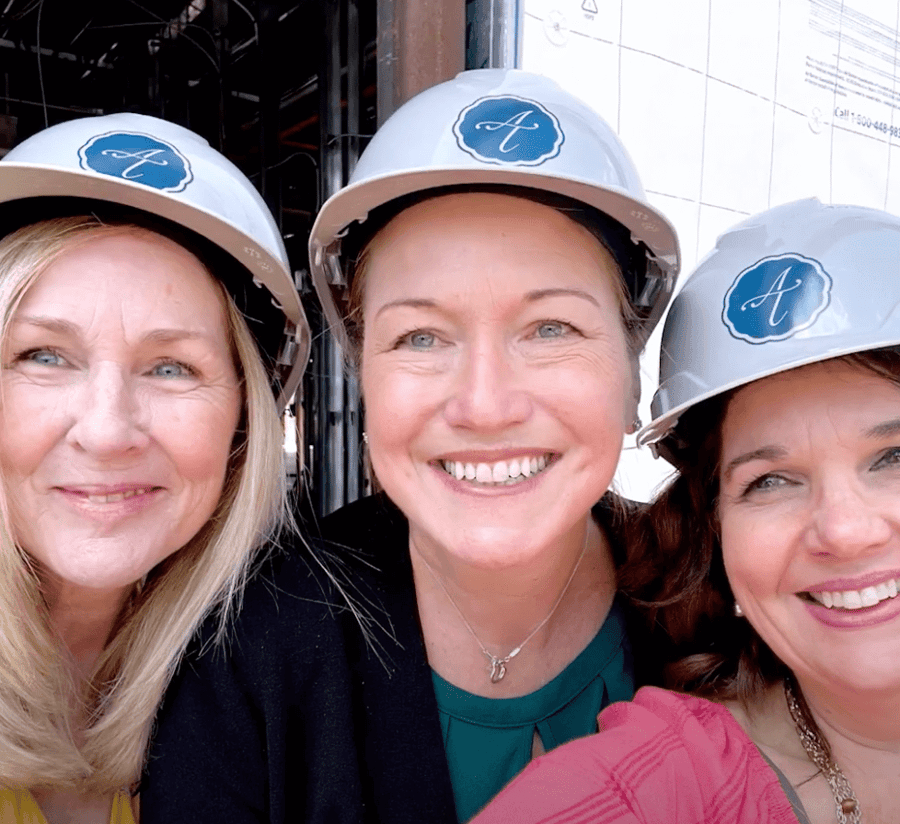 Staff members smiling with hard hats on