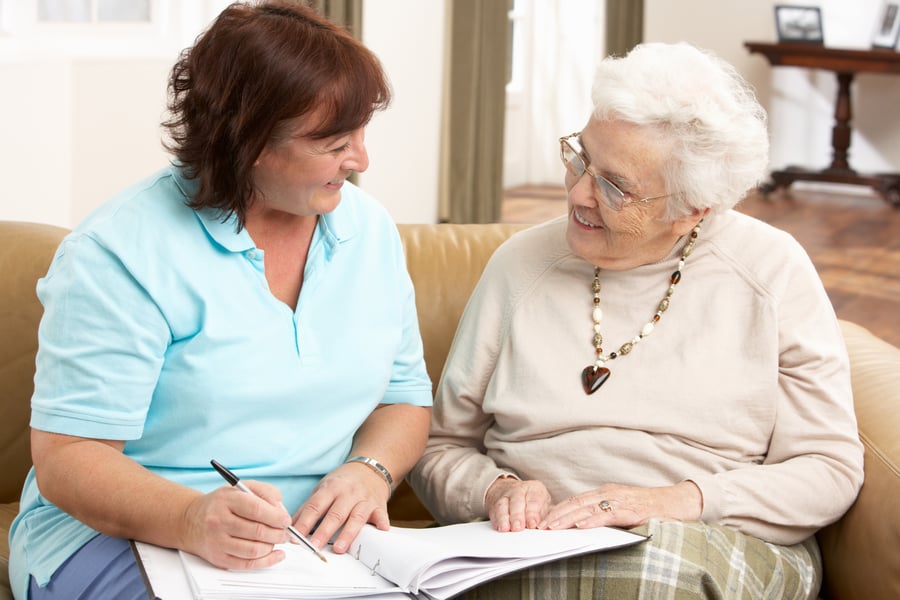 Senior and Staff smiling doing paperwork