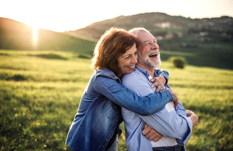seniors hugging by a field