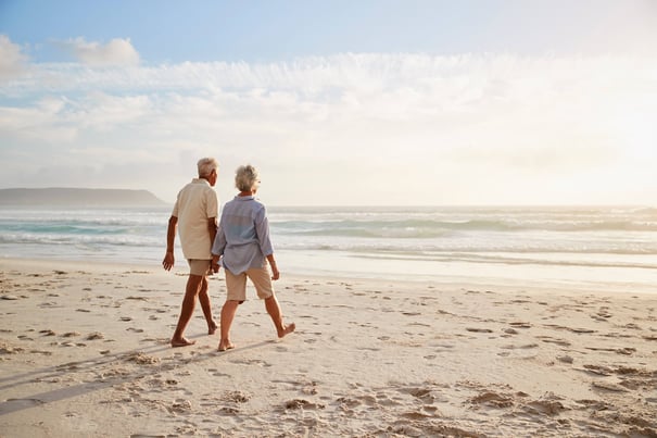 a senior couple walking by the beach