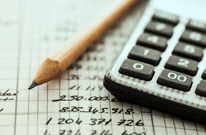 Calculator with pencil and numbers on graph paper