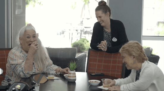 arbor terrace staff talking to residents in dining hall