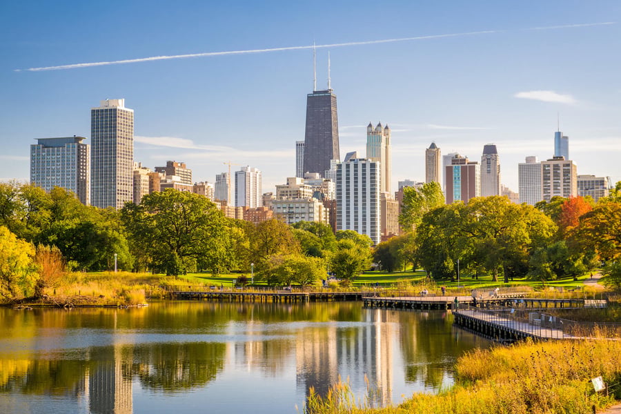 The Chicago skyline rises above a tranquil lakeside park, highlighting the scenic North Shore setting near senior living communities in Glenview, IL.