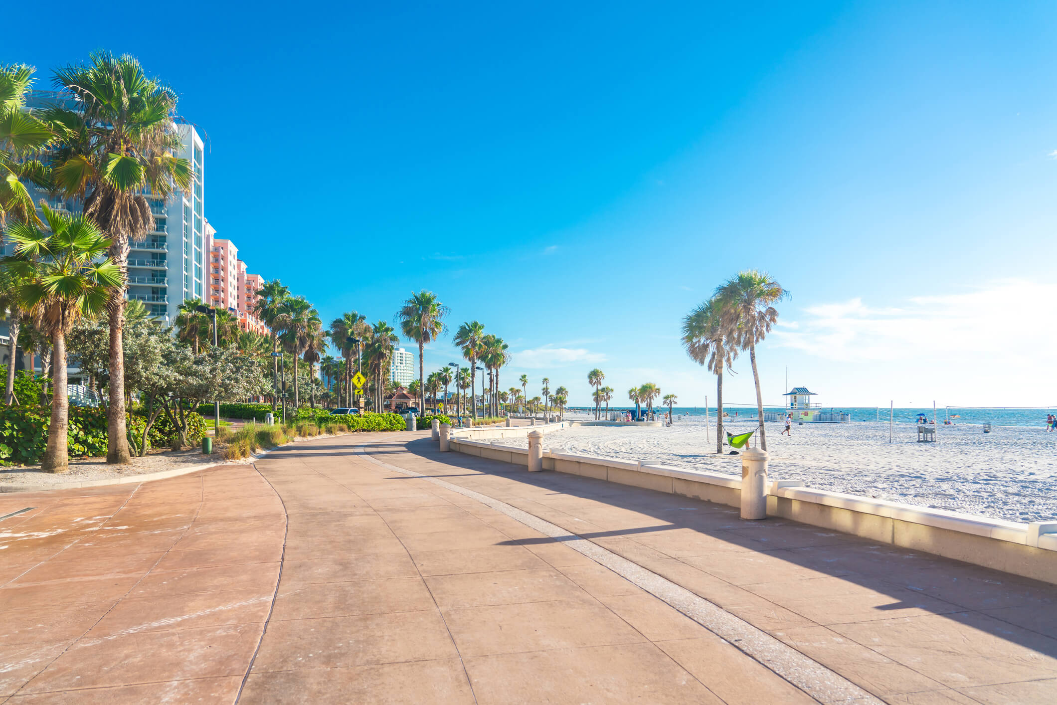 A scenic palm-lined beach walkway under clear blue skies, reflecting the coastal charm near senior living near beaches in FL.