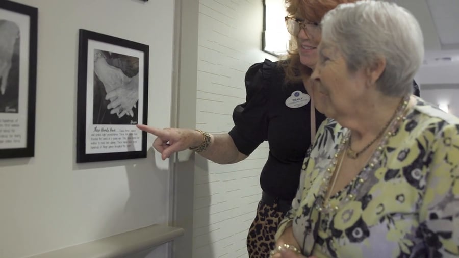 a senior lady viewing a photo with a staff member