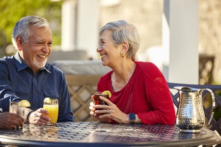 a senior couple drinking cocktails outdoors