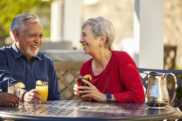 a senior couple drinking cocktails outdoors