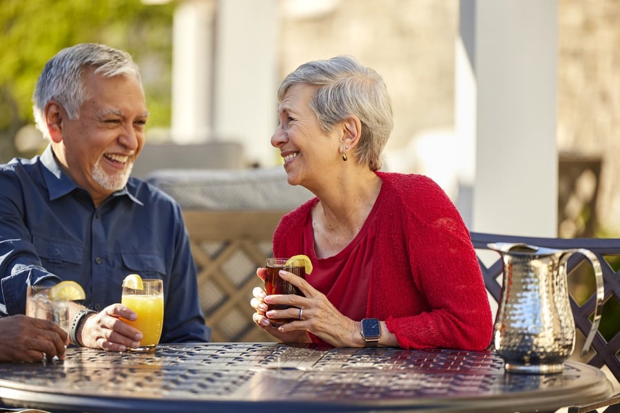 a senior couple drinking cocktails outdoors