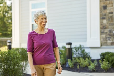 senior woman in purple walking outside