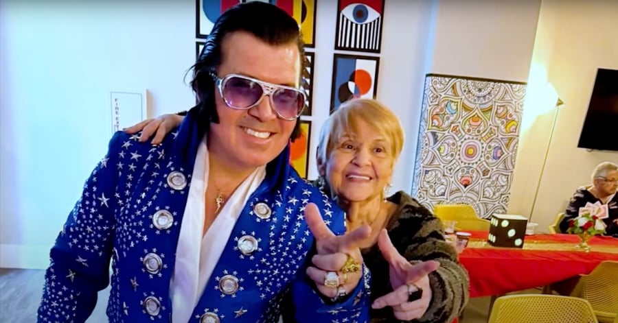A resident poses and smiles with an Elvis impersonator entertainer at a lively evening event at Mirabelle, a senior living community in South Miami, FL known for its vibrant social activities and fun programming.