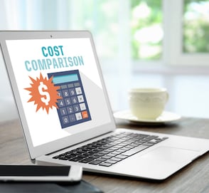 Laptop on table with a screen with a calculator that says cost comparison 