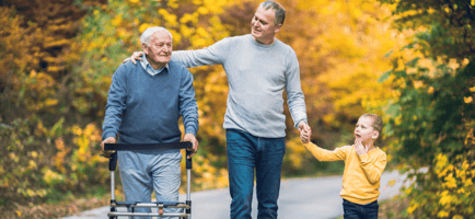 a senior man with loved ones walking outdoors during autumn