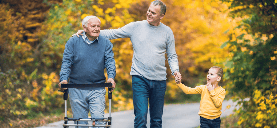 a senior man with loved ones walking outdoors during autumn