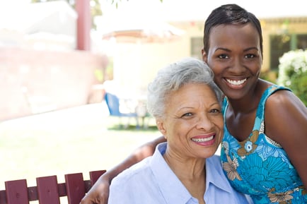 Two women smile warmly together outdoors, capturing the supportive bonds that make transitioning to dementia care near Mountainside, NJ a comforting experience for seniors and their loved ones.