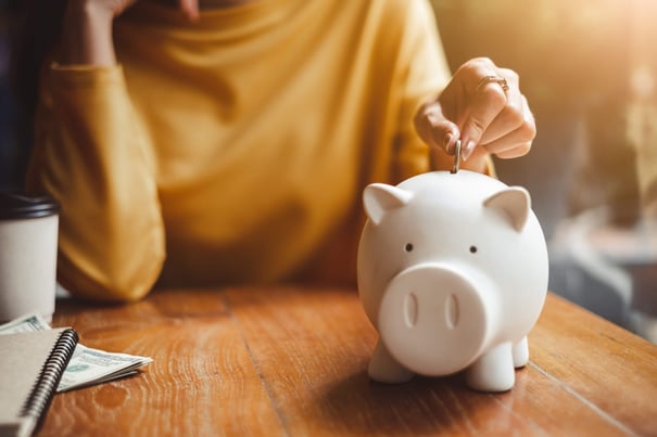 Coin being inserted into a piggy bank