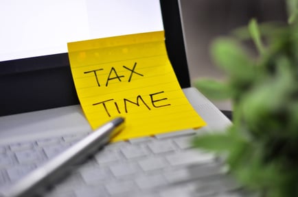 image of computer with sticky note on taxes