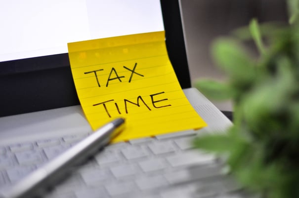 image of computer with sticky note on taxes