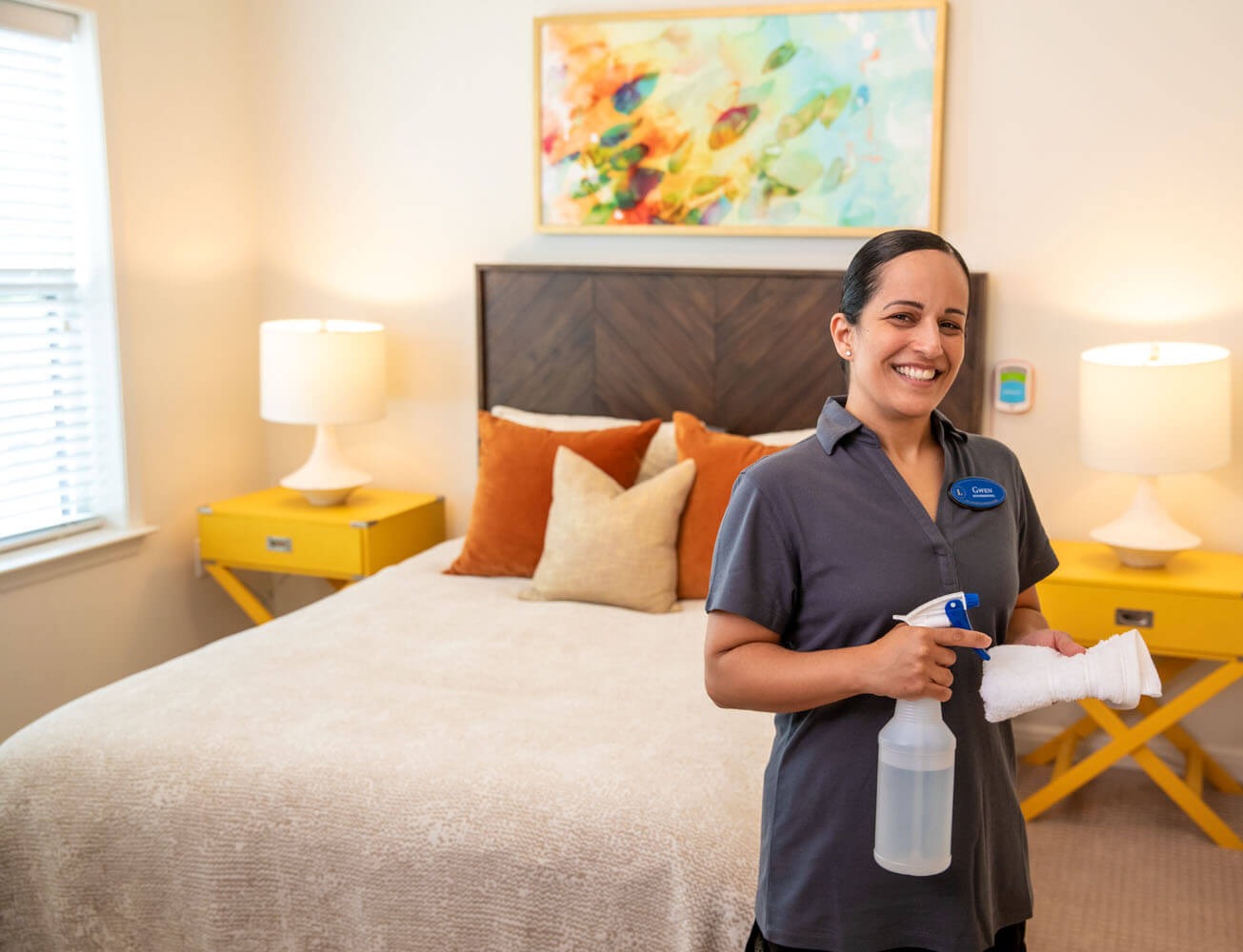 Housekeeper cleaning a bedroom at Arbor home