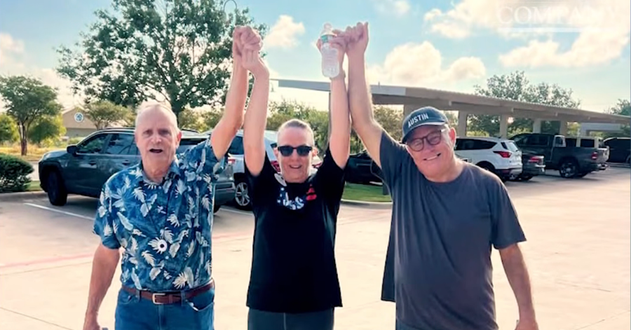 3 people holding hands and raising them above their heads