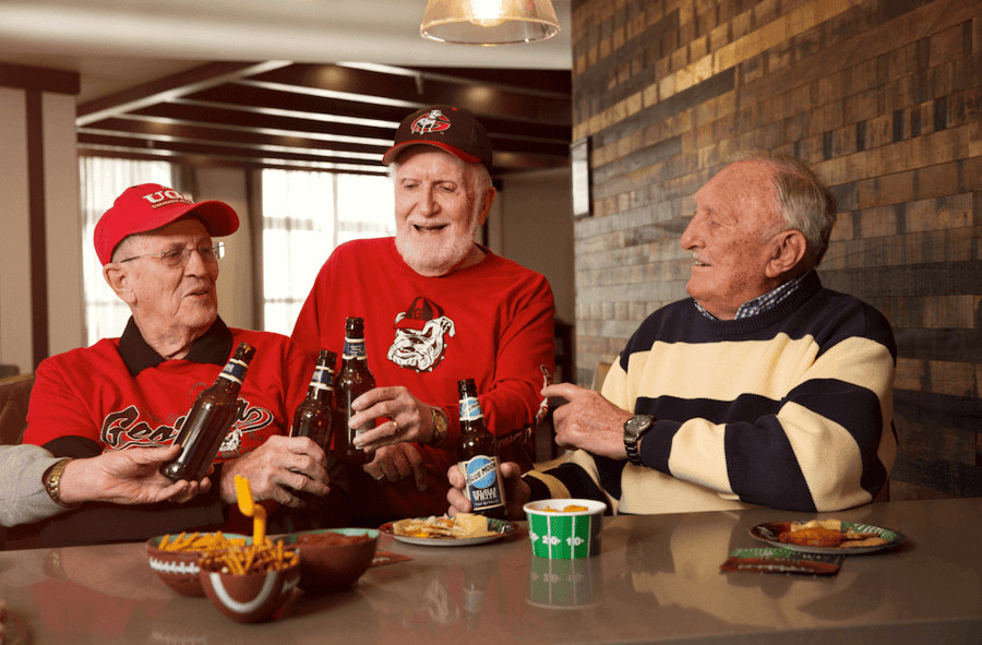 Senior residents having beer watching a game