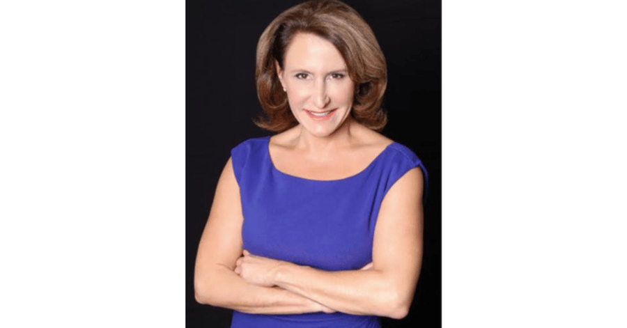 A professional headshot of a confident woman in a blue dress, the celebrity interior designer behind the personalized design services offered to residents at Mirabelle, a premier senior living community in Miami, FL.