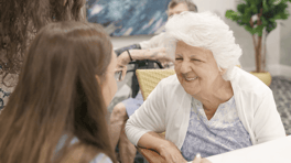A staff member shares a warm, attentive moment with a resident at Barrington Terrace assisted living in Fort Myers, FL.