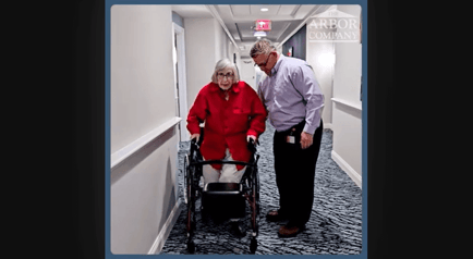 Arbor Terrace Marlton resident and staff member walking down the hall