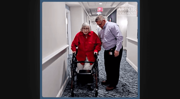 Arbor Terrace Marlton resident and staff member walking down the hall