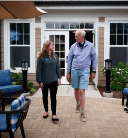 Two individuals stroll together along the patio at Arbor Terrace Glenview senior living, enjoying North Shore senior living with outdoor amenities.
