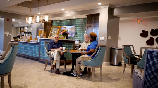 three people sitting at table in cafe