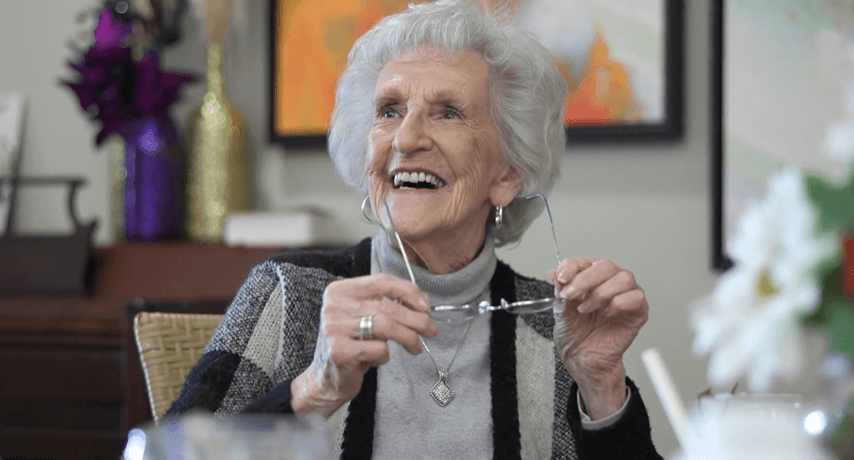Arbor Terrace Hamilton Mill resident smiling holding her glasses