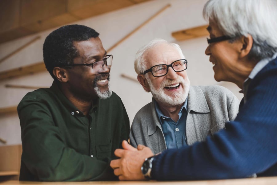 Three older adults share a hearty laugh together, capturing the joyful friendships and vibrant social connections that define the active senior lifestyle at Arbor Terrace Morris Plains, NJ.