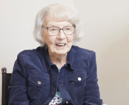 A resident smiles brightly in a cozy indoor setting, reflecting the warm and welcoming atmosphere of this senior living community in Acworth, GA.