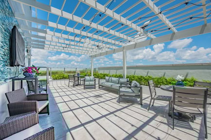 a sunny terrace with a sitting area and a breath-taking view of miami