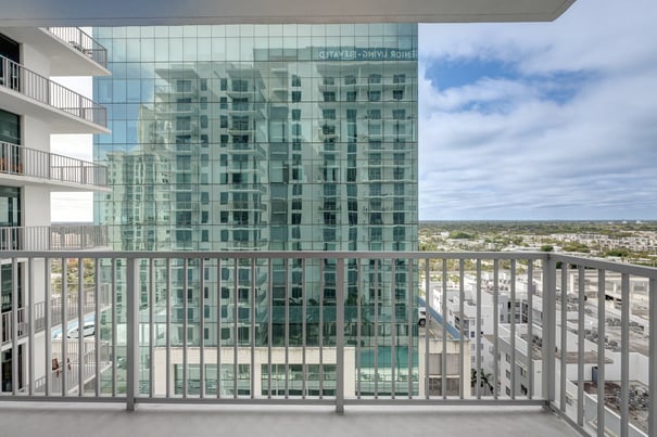 A private balcony at Mirabelle offers sweeping views of the Miami, FL skyline and surrounding neighborhood, giving residents a bright and airy retreat at this premier senior living community in South Miami.