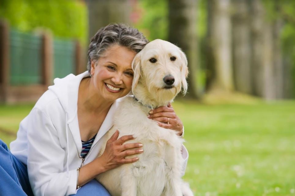 woman smiling with her dog