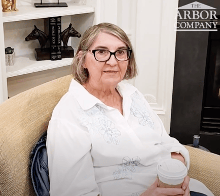 An older adult sits comfortably in a cozy lounge chair beside a fireplace, reflecting the warm, welcoming atmosphere of independent living Herndon VA at Arbor Terrace Herndon, a cherished retirement community Herndon VA.