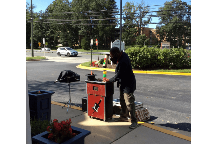 a magician doing an outdoor show at a senior living community in greenbelt