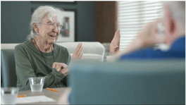A resident engaged in a lively conversation at Arbor Terrace Lakeway, highlighting the meaningful connections and attentive care found in this assisted living Lakeway TX community.