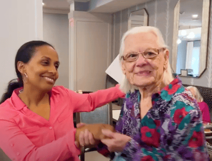 A staff member and a resident share a bright, joyful moment together, reflecting the compassionate and personalized care at our assisted living community in Gambrills, MD.