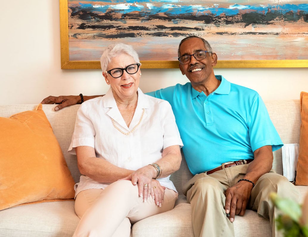 two senior citizens sitting on couch