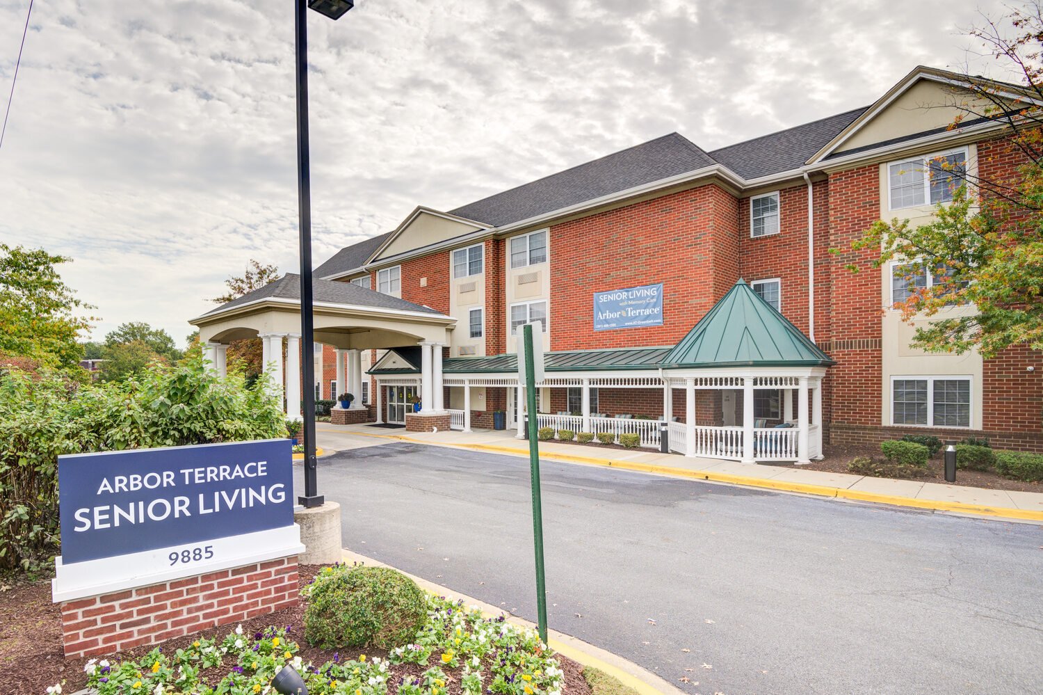 Arbor Terrace senior living sign with in front of the brick building.