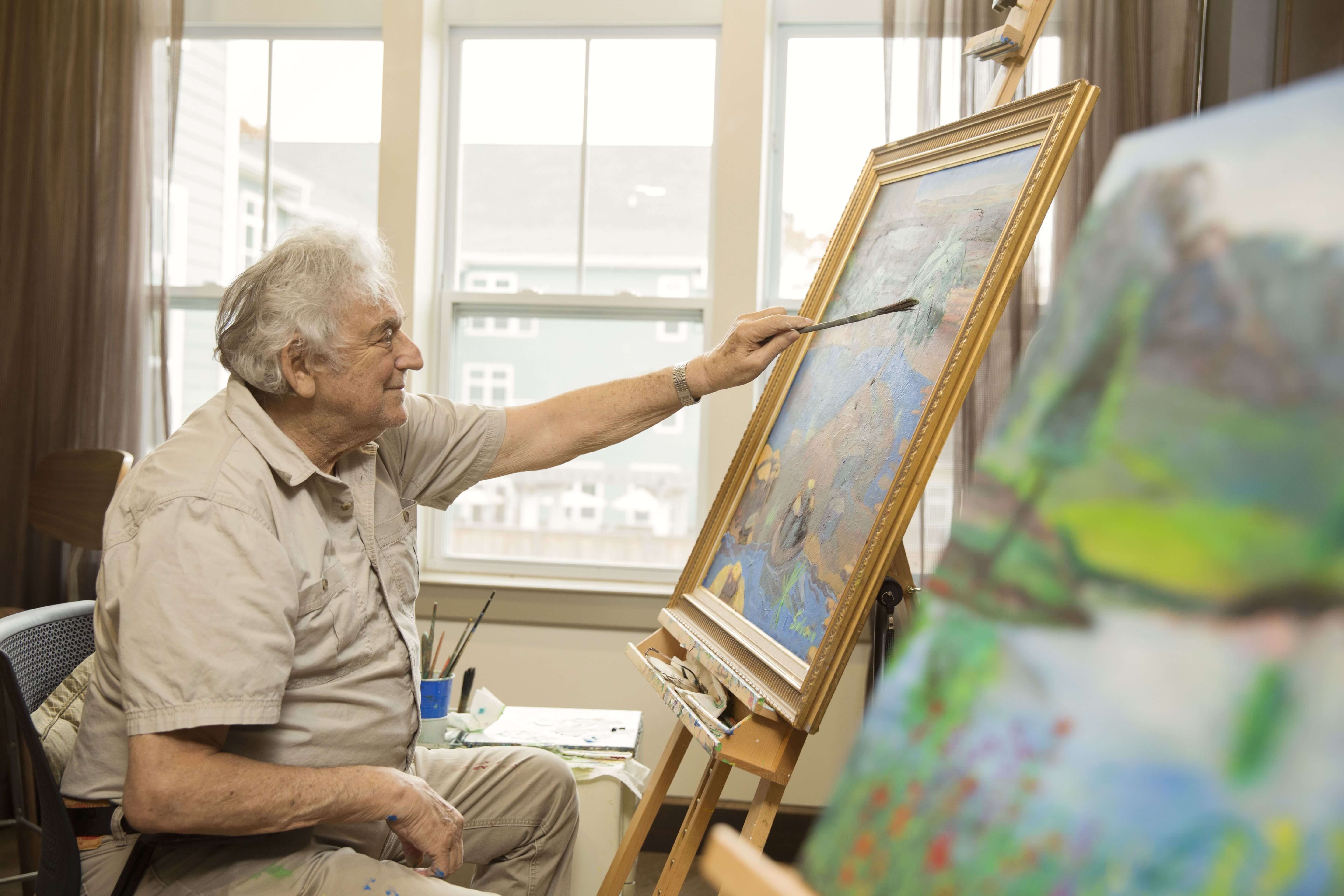 Senior male painting a picture of the outdoors