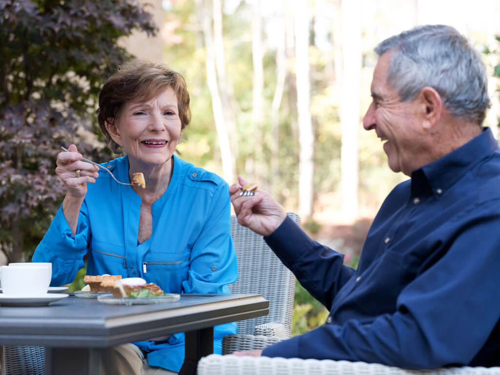 Senior couple dining outdoors at Arbor